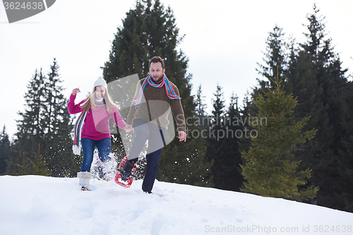 Image of couple having fun and walking in snow shoes