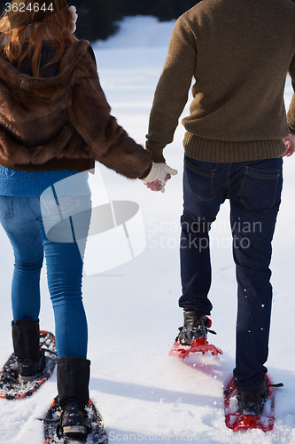 Image of couple having fun and walking in snow shoes