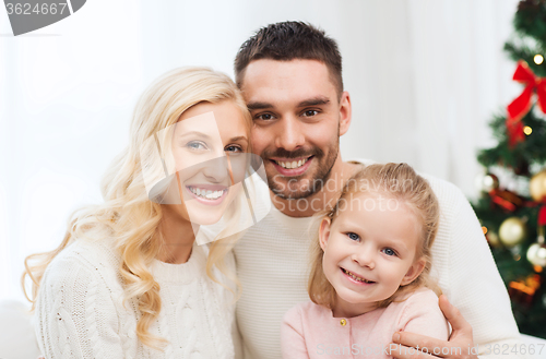 Image of happy family at home with christmas tree