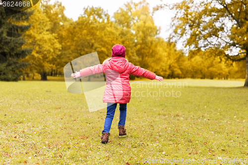 Image of happy little girl having fun in autumn park