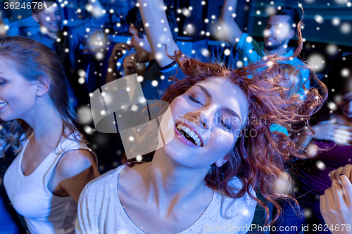 Image of smiling friends dancing in club