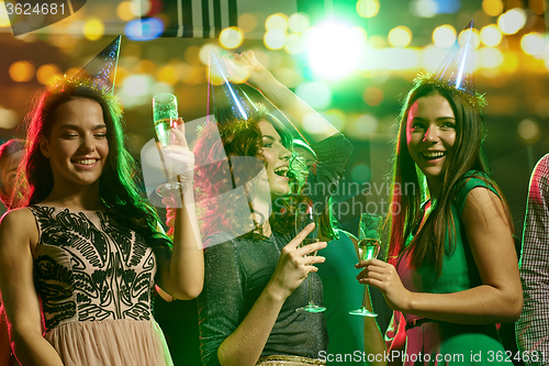 Image of happy friends with glasses of champagne in club