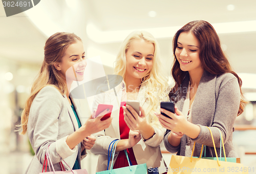 Image of happy women with smartphones and shopping bags