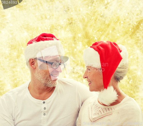 Image of happy senior couple in santa helper hats