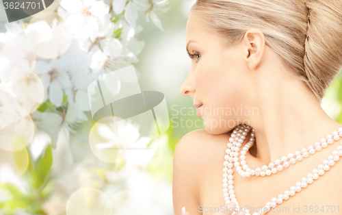 Image of woman with pearl necklace over cherry blossom