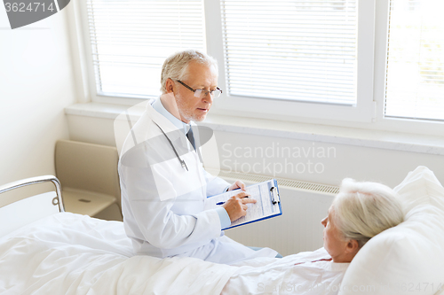 Image of senior woman and doctor with clipboard at hospital