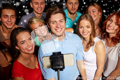 Image of friends with smartphone taking selfie in club