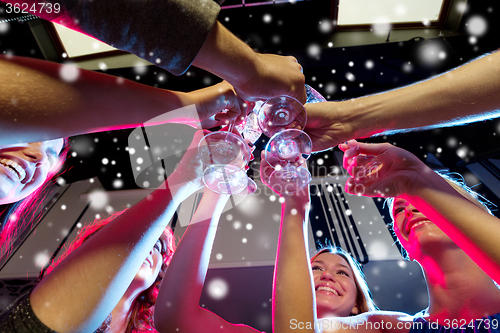 Image of smiling friends with glasses of champagne in club