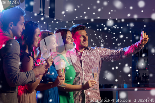 Image of friends with glasses and smartphone in club