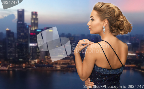 Image of woman with diamond earring over night city