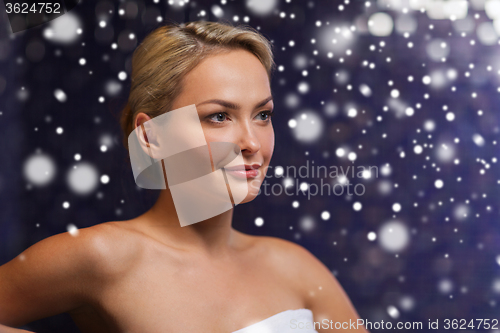 Image of beautiful woman sitting in bath towel at sauna