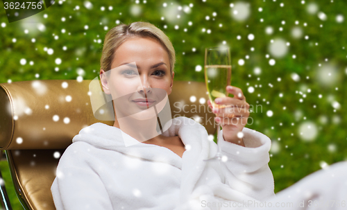 Image of beautiful young woman drinking champagne at spa