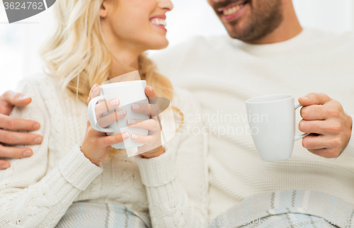Image of close up of happy couple with tea cups at home