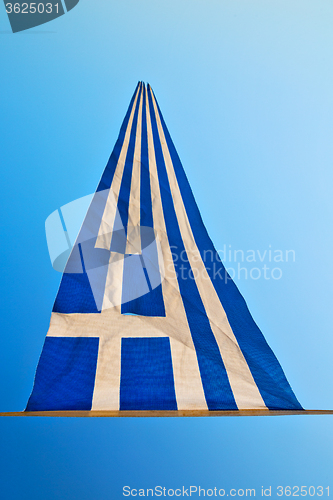 Image of waving greece flag in the blue sky and flagpole