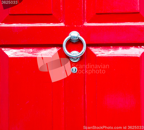 Image of red handle in london antique brown door  rusty  brass nail and l