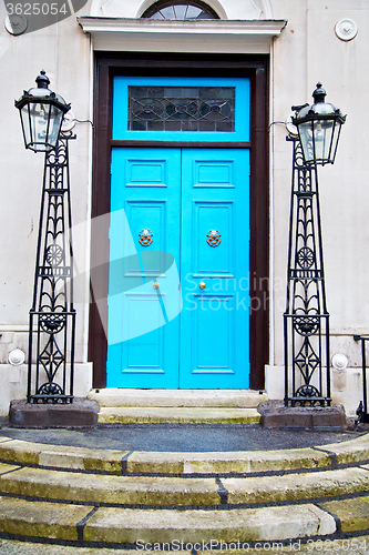 Image of  blue handle in  door  rusty  brass nail and light