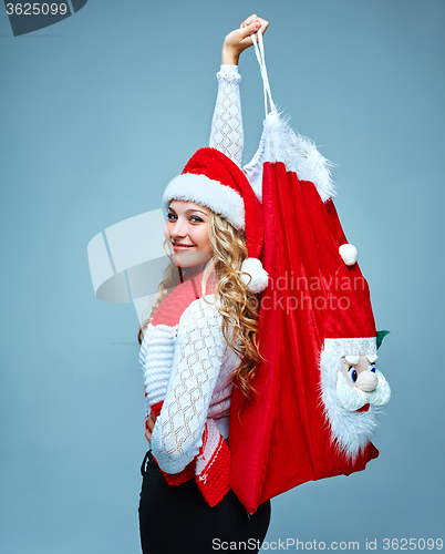 Image of Girl dressed in santa hat holding a Christmas decoration  