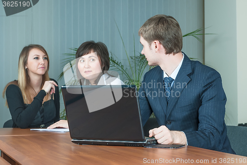 Image of Businessman talks with colleagues in office