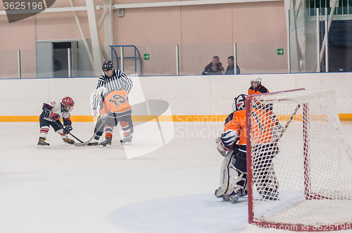 Image of Puck playing between players of ice-hockey teams