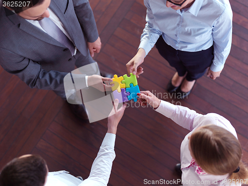 Image of business people group assembling jigsaw puzzle