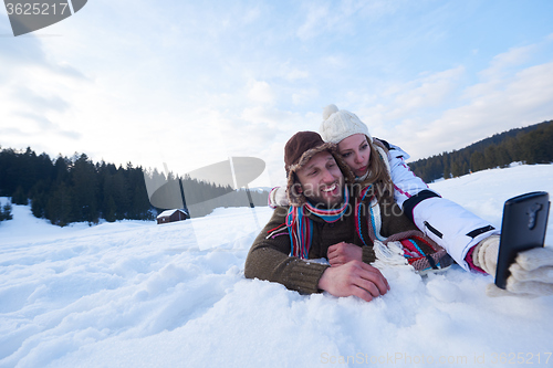 Image of romantic couple have fun in fresh snow and taking selfie