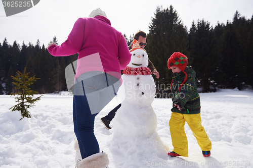 Image of happy family building snowman