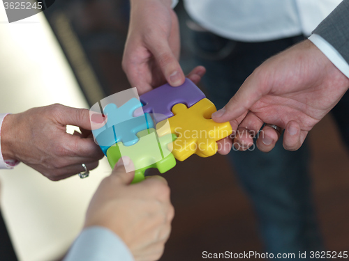 Image of business people group assembling jigsaw puzzle