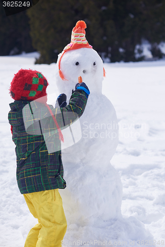 Image of boy making snowman