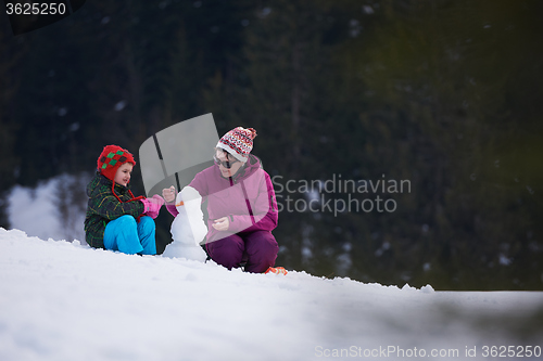 Image of happy family building snowman