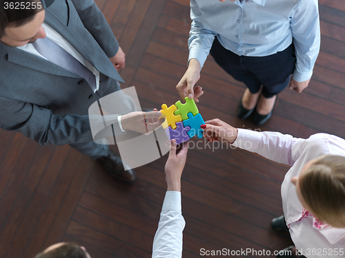 Image of business people group assembling jigsaw puzzle