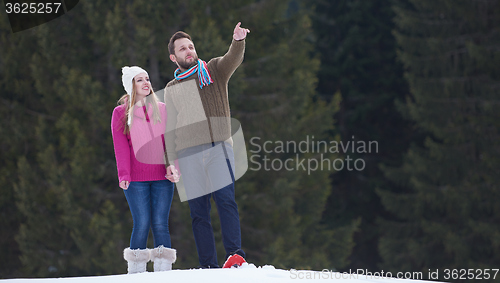 Image of couple having fun and walking in snow shoes