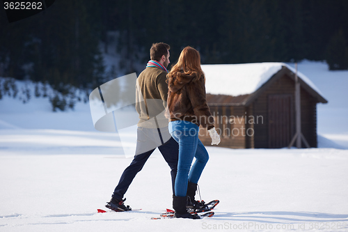 Image of couple having fun and walking in snow shoes