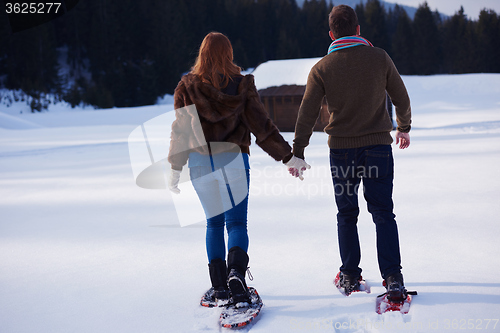 Image of couple having fun and walking in snow shoes