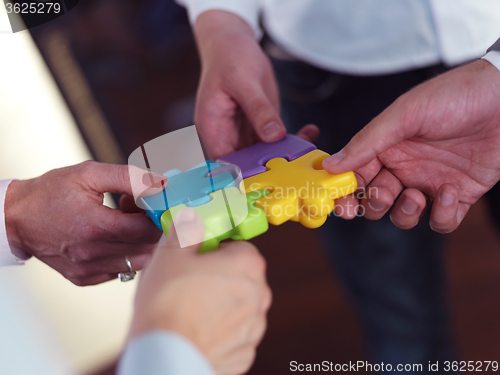 Image of business people group assembling jigsaw puzzle