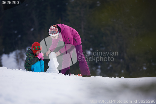 Image of happy family building snowman