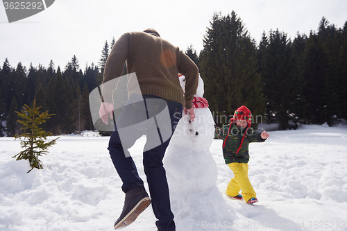 Image of happy family building snowman