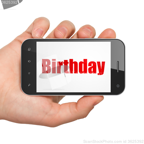 Image of Holiday concept: Hand Holding Smartphone with Birthday on display