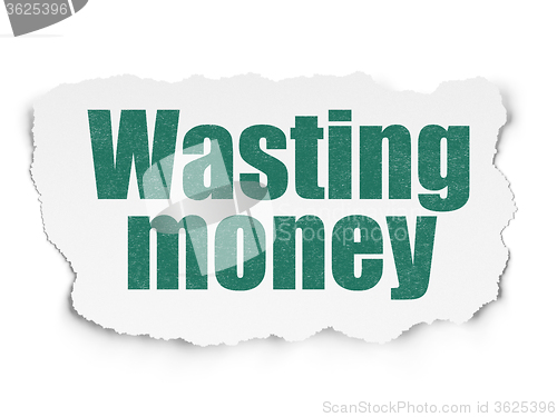 Image of Money concept: Wasting Money on Torn Paper background