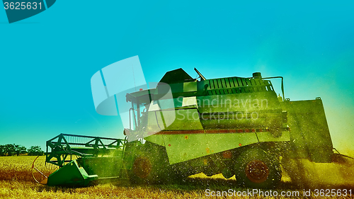 Image of Harvester combine harvesting wheat on summer day.