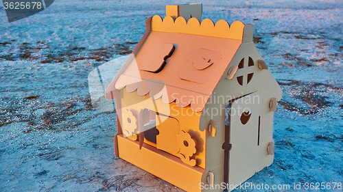 Image of Toy house made of corrugated cardboard in the sea coast at sunset.