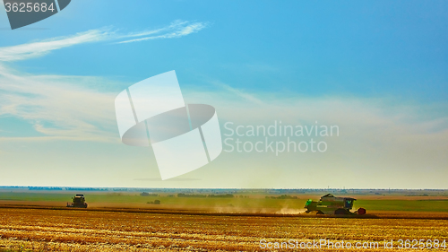 Image of Harvester combine harvesting wheat on summer day.