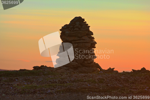 Image of Built from stone Cairn at sunset, at midnight, the polar day