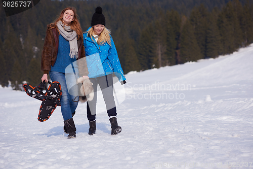 Image of female friends in beautiful winter day have relaxed walk on snow