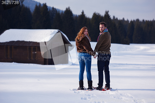 Image of couple having fun and walking in snow shoes