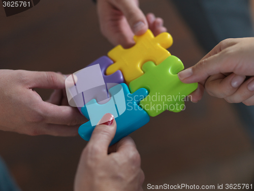 Image of business people group assembling jigsaw puzzle