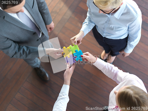 Image of business people group assembling jigsaw puzzle