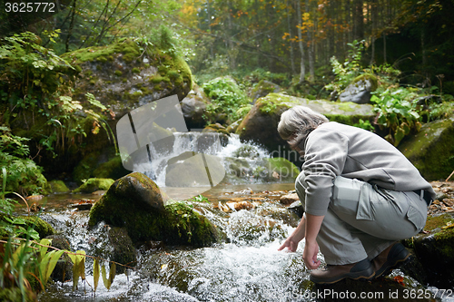 Image of man drinking fresh water from spring