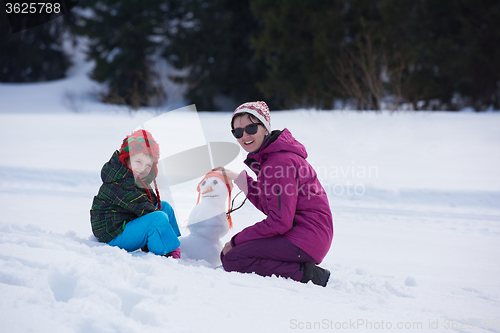 Image of happy family building snowman