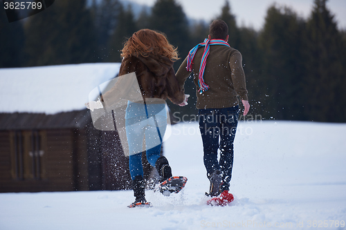 Image of couple having fun and walking in snow shoes