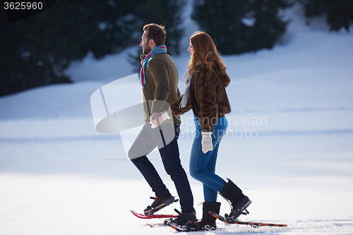 Image of couple having fun and walking in snow shoes